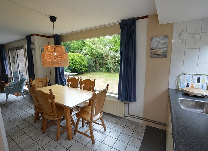 Gezellige woonkamer in Bungalow Verste Coogh 56, De Dennen, Texel, met comfortabele banken en uitzicht op de natuur.