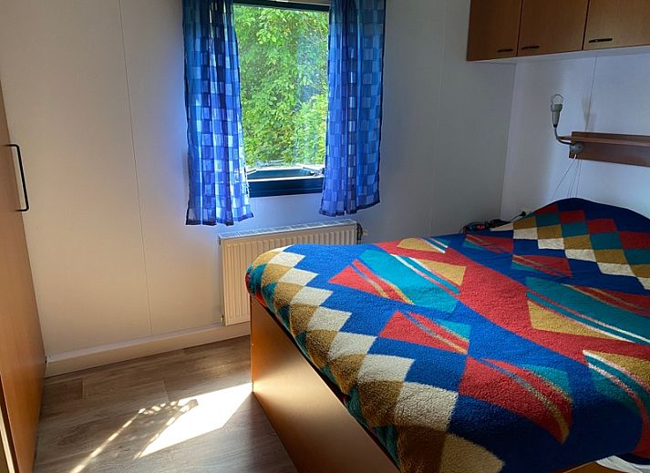 Buitenterras van vakantiehuis Vakantiepark De Bremakker in De Dennen Texel, omgeven door groen en voorzien van tuinmeubilair.