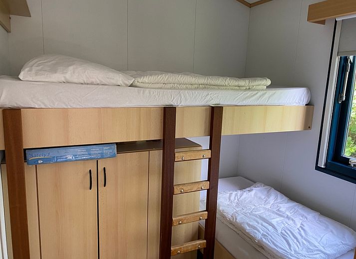 Buitenterras van vakantiehuis Vakantiepark De Bremakker in De Dennen Texel, omgeven door groen en voorzien van tuinmeubilair.