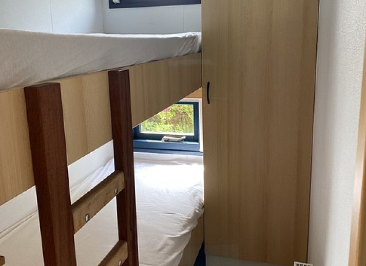 Buitenterras van vakantiehuis Vakantiepark De Bremakker in De Dennen Texel, omgeven door groen en voorzien van tuinmeubilair.