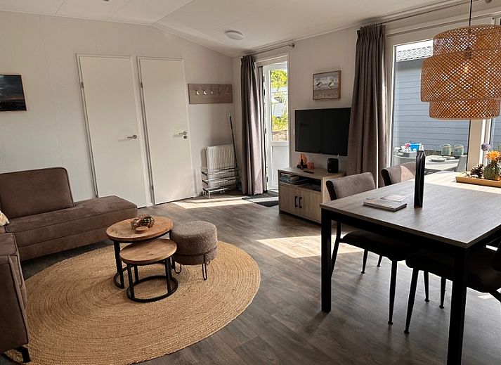 Geraeumige Terrasse mit Sonnenschirm im Vakantiepark de Bremakker - Chalet Wulk, De Dennen, Texel, ideal fuer Mahlzeiten im Freien.