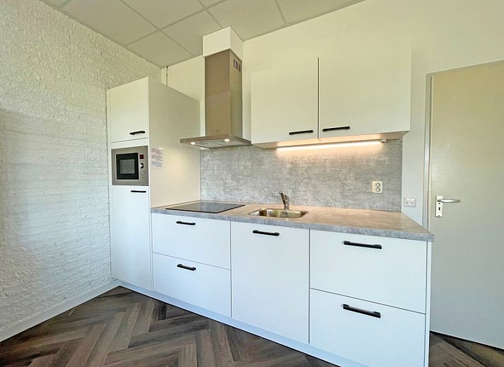 Stilvolle Sitzecke im Apartment Bos en Duin 02, De Dennen, Texel mit bequemem Sofa und dekorativen Elementen.