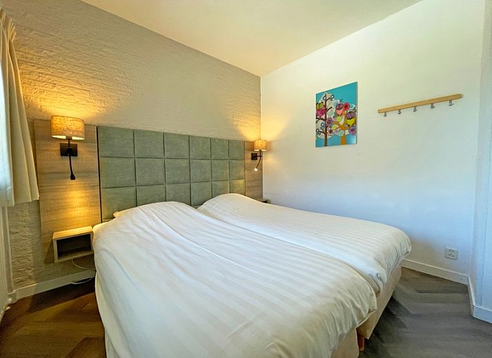 Gemuetliche Sitzecke im Apartment Bos en Duin 03, De Dennen, Texel mit bequemem Sessel und Blick auf die Terrasse.