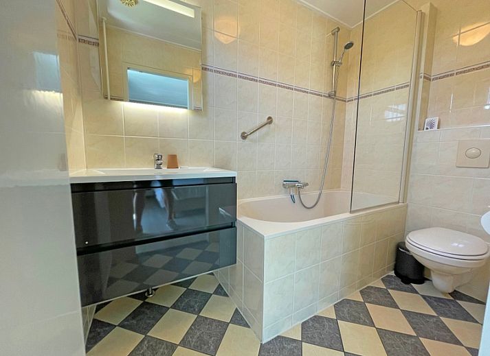 Helles Wohnzimmer der Ferienwohnung Bos en Duin 16 in De Dennen Texel mit gemuetlicher Sitzecke.