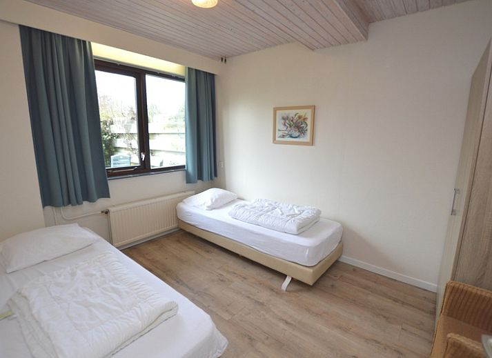 Lichte woonkamer in vakantiehuis Roos, De Dennen, Texel met uitzicht op tuin.