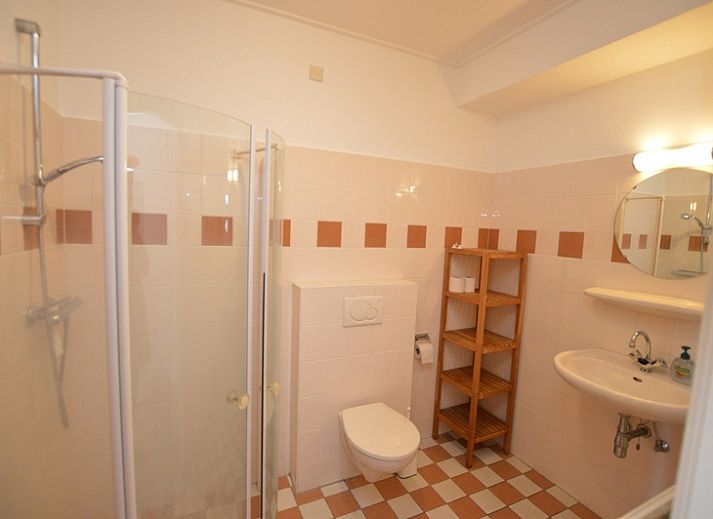 Lichte woonkamer in vakantiehuis Roos, De Dennen, Texel met uitzicht op tuin.