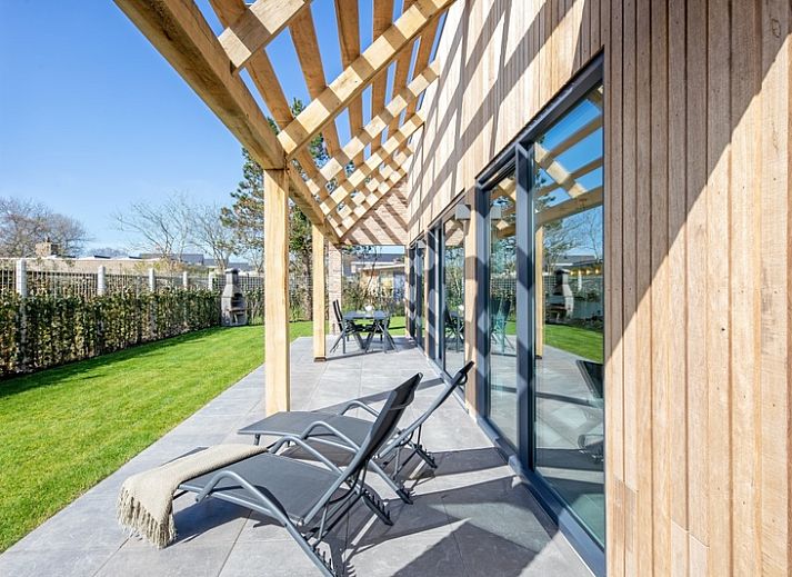 Der Bungalowpark 't Luwe Land in De Dennen, Texel, bietet ein modernes Ferienhaus mit einer sonnigen Terrasse und gruener Umgebung.