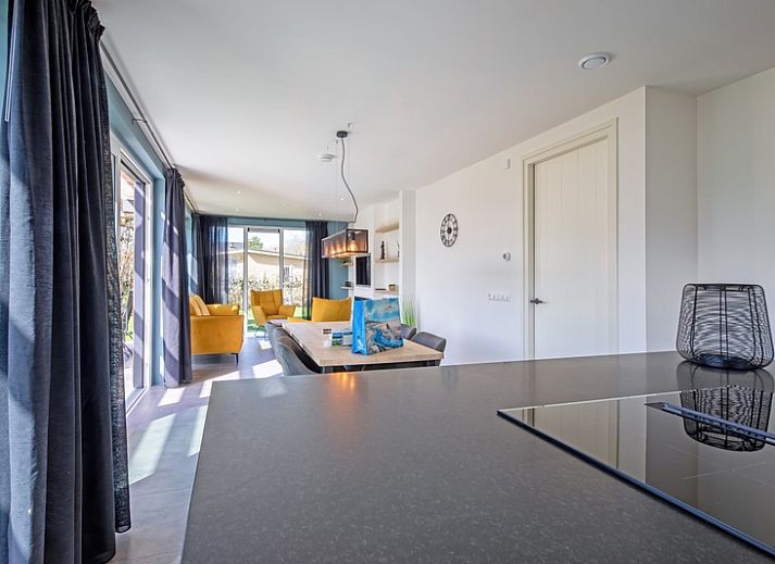 Geniessen Sie die Sonne auf der Terrasse des Bungalowparks 't Luwe Land in De Dennen, Texel, mit bequemen Liegestuehlen.