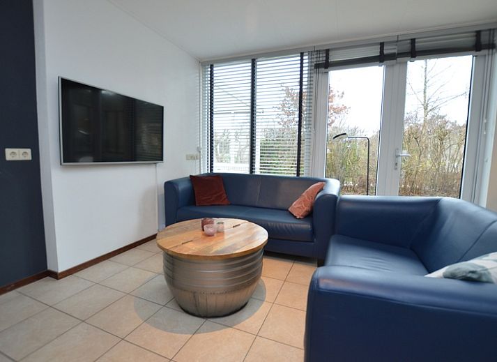 Lichte woonkamer in Vakantiehuis de Parel 244, De Dennen, Texel met comfortabele zithoek en eetgedeelte.