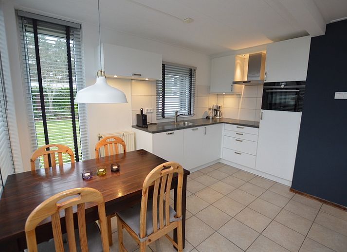 Lichte woonkamer in Vakantiehuis de Parel 244, De Dennen, Texel met comfortabele zithoek en eetgedeelte.