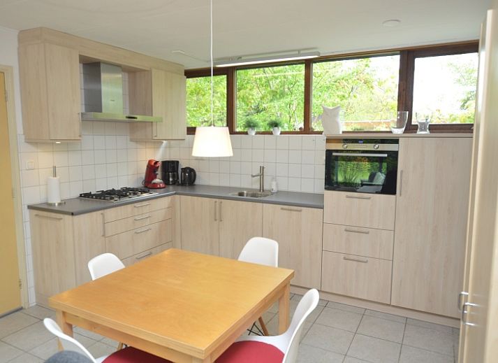 Gemuetliches Wohnzimmer des Ferienhauses de Parel 286 in De Dennen, Texel, mit farbenfroher Einrichtung und Gartenblick.