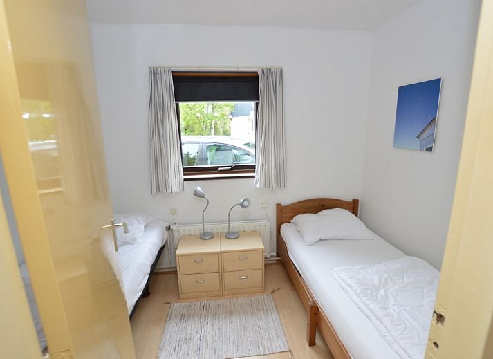 Gemuetliches Wohnzimmer des Ferienhauses de Parel 286 in De Dennen, Texel, mit farbenfroher Einrichtung und Gartenblick.