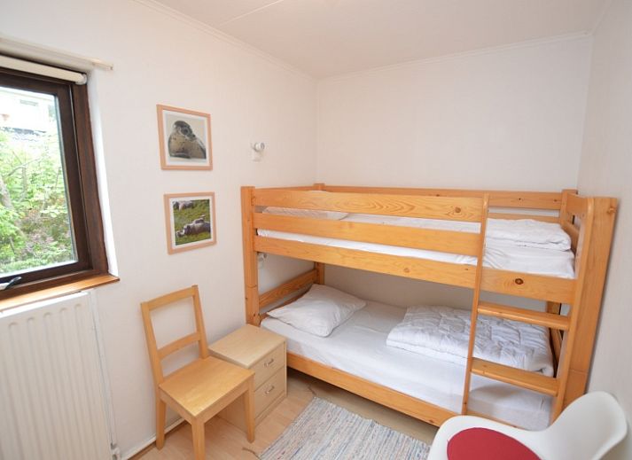 Gemuetliches Wohnzimmer des Ferienhauses de Parel 286 in De Dennen, Texel, mit farbenfroher Einrichtung und Gartenblick.