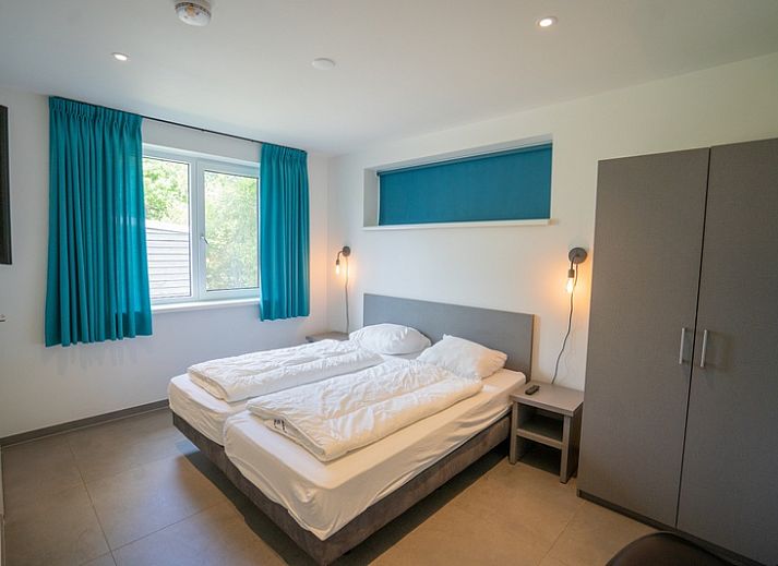 Gemuetliches Wohnzimmer des Ferienhauses de Parel 174 in De Dennen, Texel mit moderner Einrichtung und Kamin.