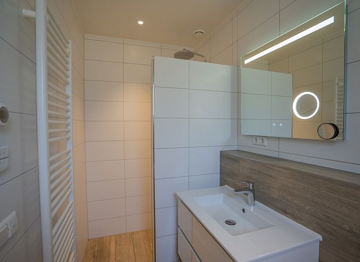 Gemuetliches Wohnzimmer des Ferienhauses de Parel 174 in De Dennen, Texel mit moderner Einrichtung und Kamin.