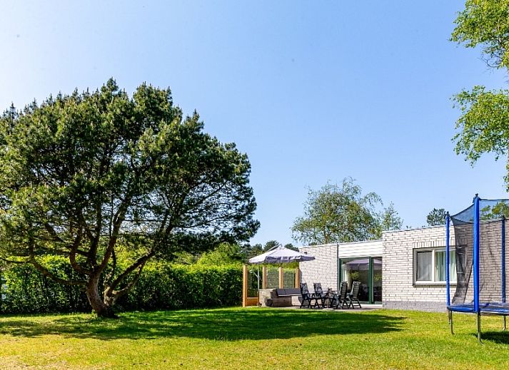 Geniessen Sie den gruenen Garten des Ferienhauses de Parel 168 in De Dennen, Texel, ideal fuer Entspannung auf den Watteninseln.