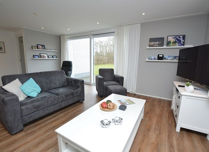 Geniessen Sie den gruenen Garten des Ferienhauses de Parel 168 in De Dennen, Texel, ideal fuer Entspannung auf den Watteninseln.