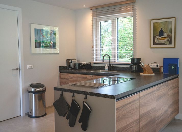 Gezellige woonkamer van Vakantiehuis de Parel 180 in De Dennen, Texel met uitzicht op de tuin.