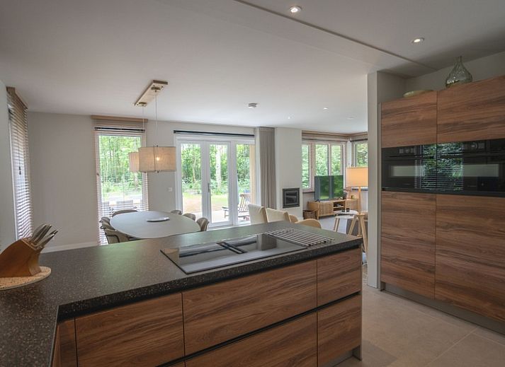 Gezellige woonkamer van Vakantiehuis de Parel 180 in De Dennen, Texel met uitzicht op de tuin.