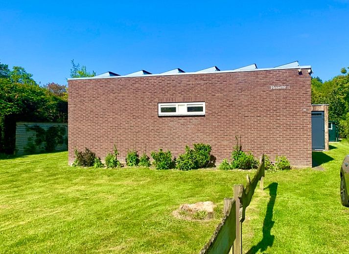 Blick auf das Ferienhaus Hesselte in De Dennen, Texel, umgeben von viel Gruen.