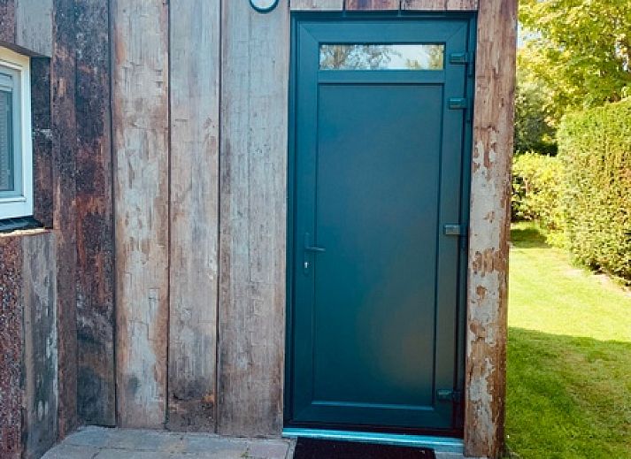 Blick auf das Ferienhaus Hesselte in De Dennen, Texel, umgeben von viel Gruen.