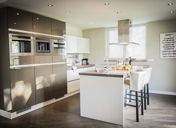 Gemuetliches Wohnzimmer in der Villa bij Zee, Bungalowpark 't Hoogelandt, Texel. Gemuetliche Sitzecke mit Kamin und Blick auf De Dennen.