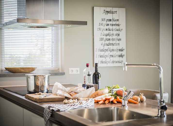 Gemuetliches Wohnzimmer in der Villa bij Zee, Bungalowpark 't Hoogelandt, Texel. Gemuetliche Sitzecke mit Kamin und Blick auf De Dennen.