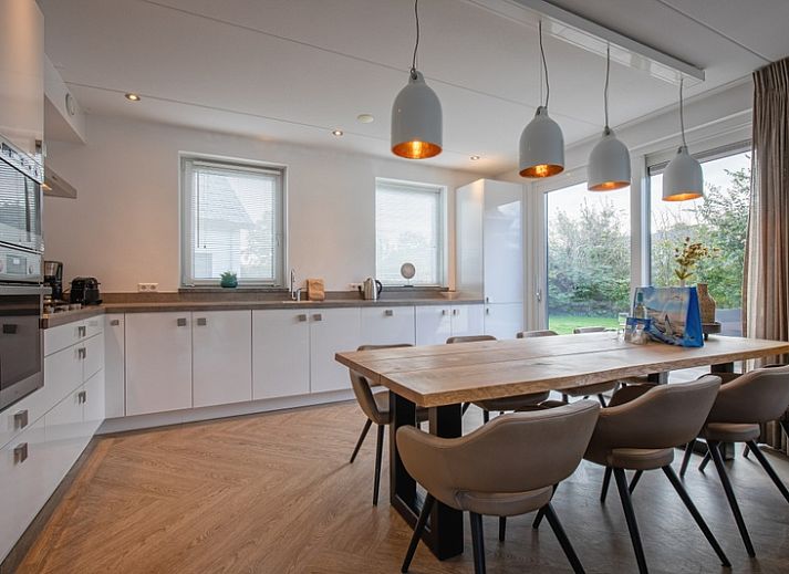 Gemuetliches Wohnzimmer in der Villa Bloem en Bos, Bungalowpark 't Hoogelandt, De Dennen, Texel, mit bequemen Sofas und Blick auf den Garten.