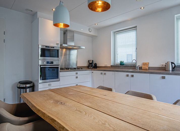 Gemuetliches Wohnzimmer in der Villa Bloem en Bos, Bungalowpark 't Hoogelandt, De Dennen, Texel, mit bequemen Sofas und Blick auf den Garten.