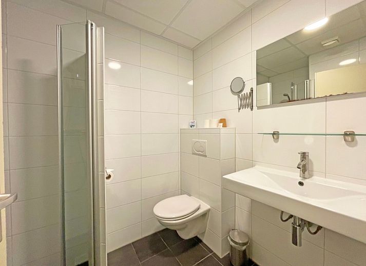 Modern eingerichtetes Wohnzimmer des Appartements Bos en Duin 05, De Dennen, Texel mit viel natuerlichem Licht.