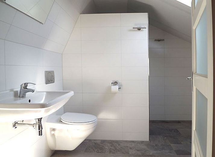 Gemuetliches Wohnzimmer im Ferienhaus Gortersmient 326, De Dennen, Texel mit bequemen Sitzgelegenheiten und Kamin.