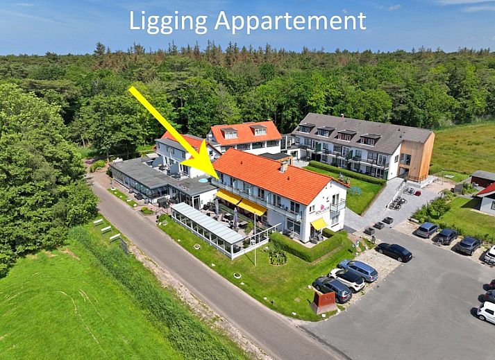 Helles Wohnzimmer des Appartements Bos en Duin 19, Texel mit gemuetlicher Sitzecke und grossen Fenstern.