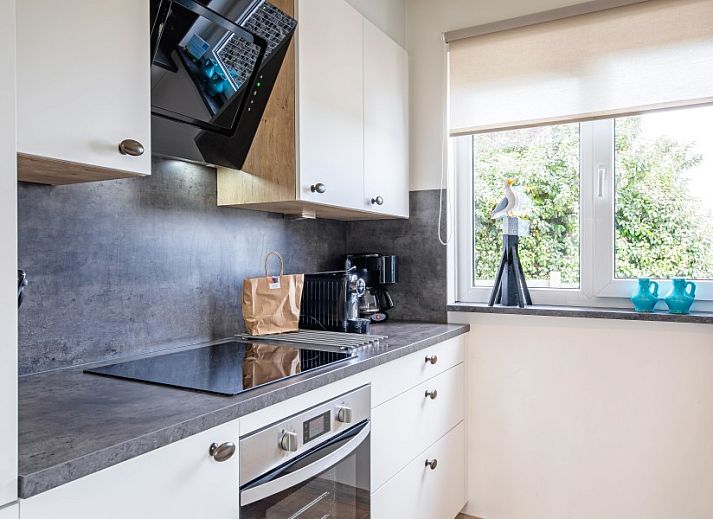 Gezellige woonkamer van Wulpenweid 14 Zeehond in De Dennen Texel met uitzicht op de tuin.