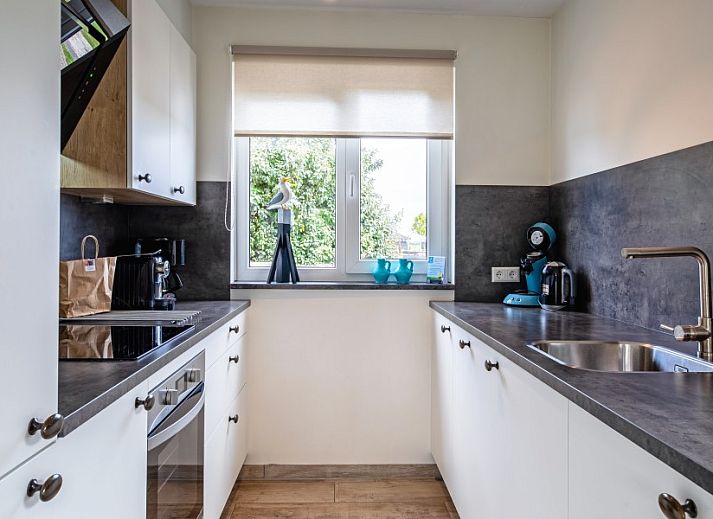 Gezellige woonkamer van Wulpenweid 14 Zeehond in De Dennen Texel met uitzicht op de tuin.