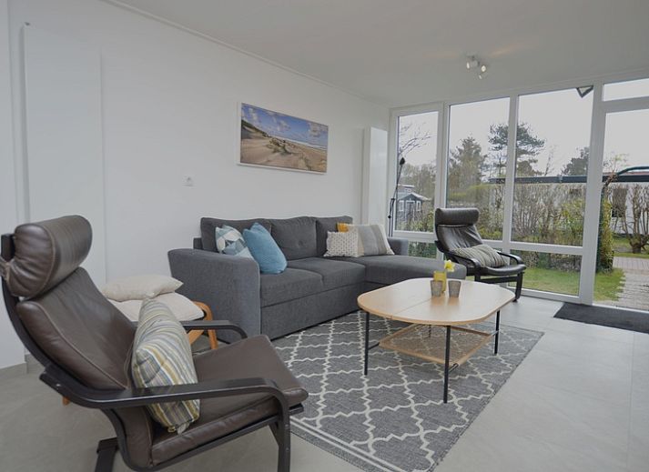 Ferienhaus Tempelierweg 38 in De Dennen, Texel, umgeben von gruener Natur und einer sonnigen Terrasse.