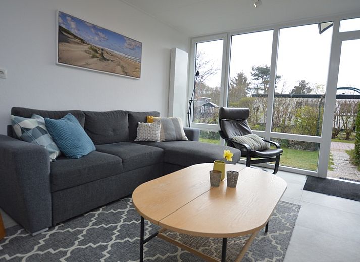 Ferienhaus Tempelierweg 38 in De Dennen, Texel, umgeben von gruener Natur und einer sonnigen Terrasse.