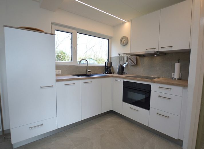 Helles Wohnzimmer des Ferienhauses Tempelierweg 38 in De Dennen, Texel, mit komfortabler Sitzecke und modernem Mobiliar.