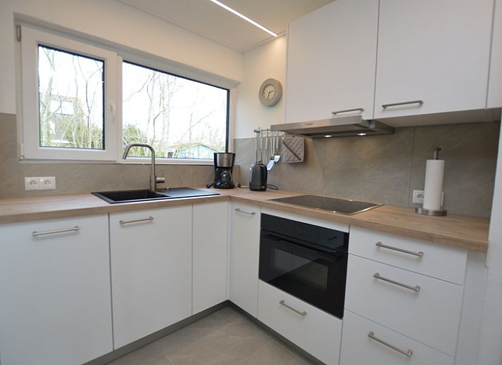 Helles Wohnzimmer des Ferienhauses Tempelierweg 38 in De Dennen, Texel, mit komfortabler Sitzecke und modernem Mobiliar.