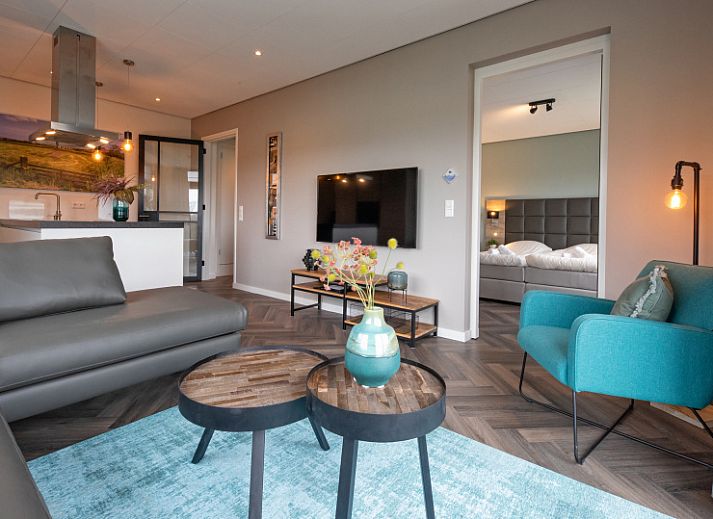 Geraeumiges Wohnzimmer im Apartment Bos en Duin 01, De Dennen, Texel mit Blick auf die Natur.