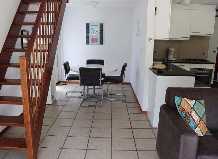 Gemuetliches Wohnzimmer im Ferienhaus Gortersmient 260, De Dennen, Texel, mit moderner Kueche und Essecke.