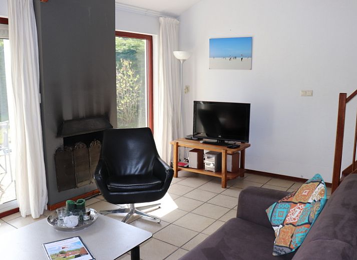 Gemuetliches Wohnzimmer im Ferienhaus Gortersmient 260, De Dennen, Texel, mit moderner Kueche und Essecke.
