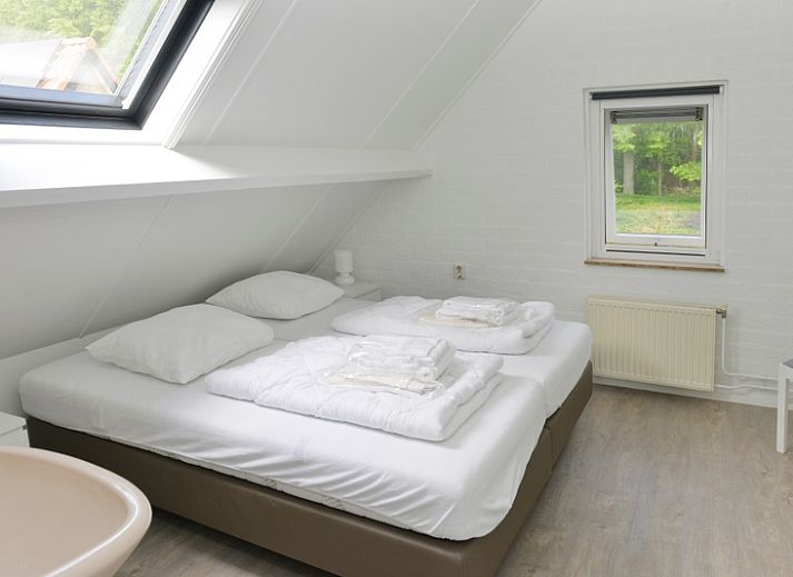 Gezellige woonkamer van vakantiehuis Turel in De Dennen, Texel met uitzicht op terras.