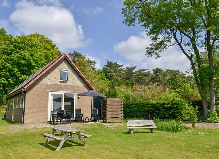 Gezellige woonkamer van vakantiehuis Turel in De Dennen, Texel met uitzicht op terras.