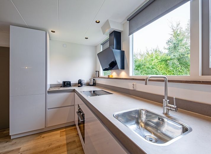 Gemuetliches Wohnzimmer im Ferienhaus De Parel 166, Bungalowpark De Parel, Texel. Moderne Einrichtung mit Kamin.