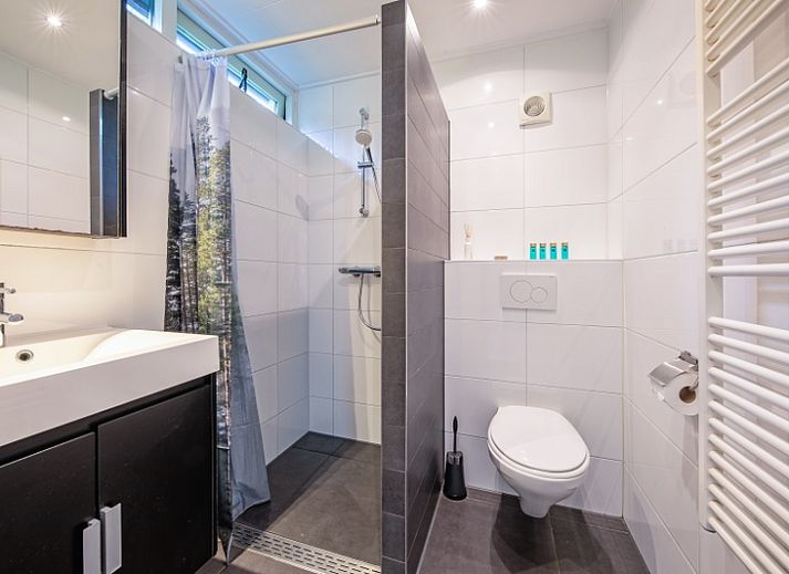 Gemuetliches Wohnzimmer im Ferienhaus De Parel 166, Bungalowpark De Parel, Texel. Moderne Einrichtung mit Kamin.