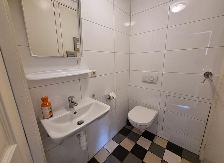 Terrasse des Ferienhauses Boszicht in De Dennen Texel mit bequemen Sitzgelegenheiten und gruener Umgebung.