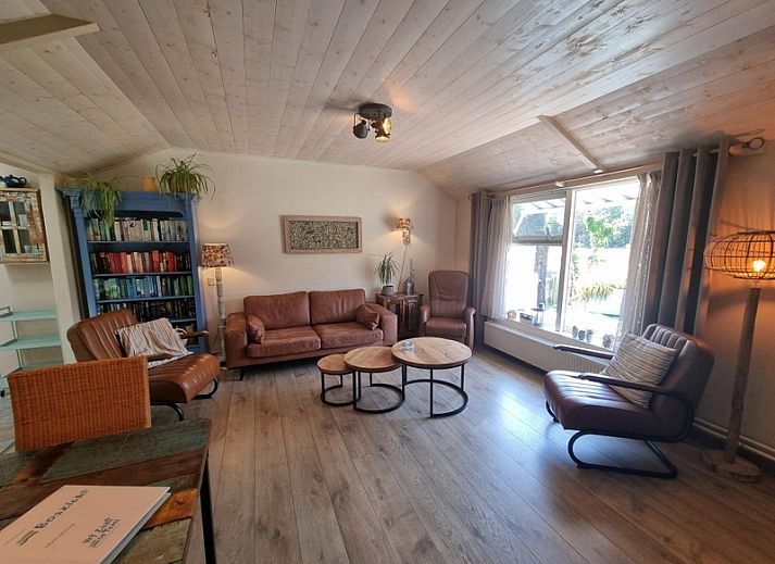 Terrasse des Ferienhauses Boszicht in De Dennen Texel mit bequemen Sitzgelegenheiten und gruener Umgebung.