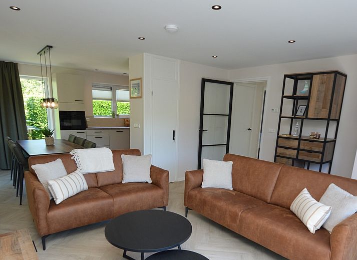 Modernes Wohnzimmer im Bungalow 't Hoogelandt 58, Texel, mit bequemen Sofas und stilvollen Moebeln.