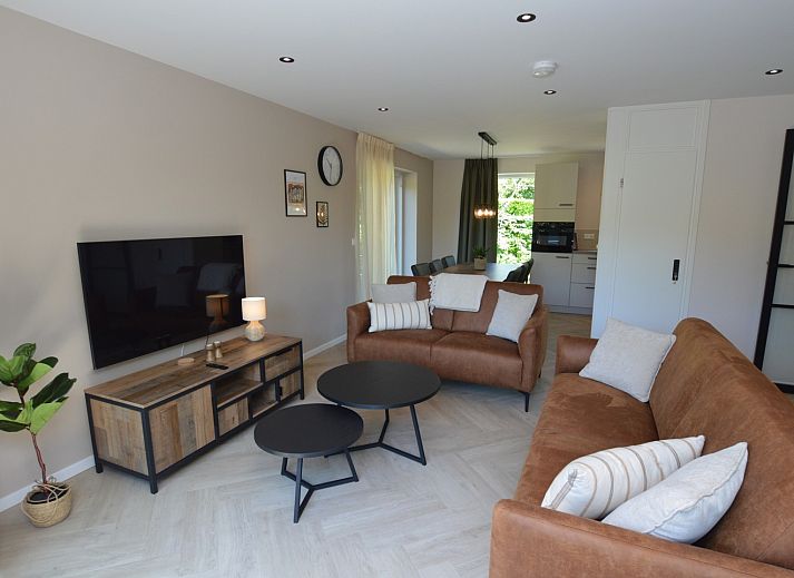 Modernes Wohnzimmer im Bungalow 't Hoogelandt 58, Texel, mit bequemen Sofas und stilvollen Moebeln.