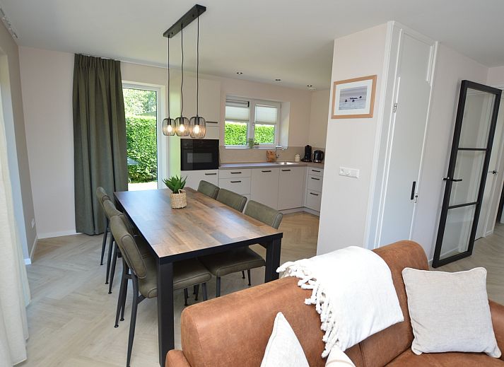 Modernes Wohnzimmer im Bungalow 't Hoogelandt 58, Texel, mit bequemen Sofas und stilvollen Moebeln.